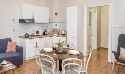 a kitchen and living room with a table and chairs at 6 Continents Apartments by Adrez in Prague