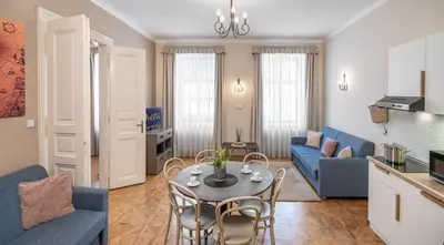 a living room with a table and a blue couch at 6 Continents Apartments by Adrez in Prague