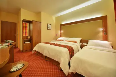 a hotel room with two beds and a large mirror at Maxmilian Lifestyle Resort in Loučeň