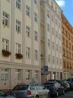 a large building with cars parked in front of it at Nice Apartments Prague in Prague