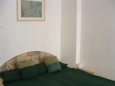 a bedroom with a green bed with two pillows at Nice Apartments Prague in Prague