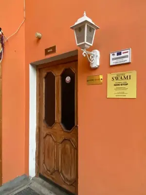 an orange building with a door and a light at Hotel Swami in Mělník