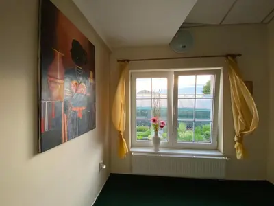 a room with a window with a vase with flowers in it at Hotel Swami in Mělník