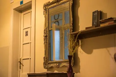 a mirror on a wall next to a window at Hostel Dakura in Prague