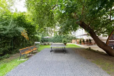 a picnic table and benches in a park at Hostel Dakura in Prague
