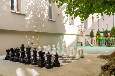 a chessboard is sitting on a sidewalk next to a playground at Hostel Dakura in Prague
