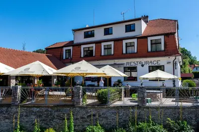 a restaurant with umbrellas in front of a building at Hotel U Berounky in Srbsko