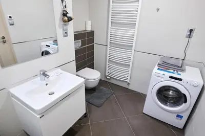 a bathroom with a washing machine and a sink at Residence Nad Vltavou in Prague