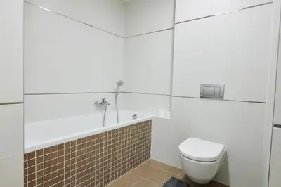 a white bathroom with a toilet and a bath tub at Residence Nad Vltavou in Prague