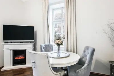 a dining room with a table and chairs and a fireplace at Old Town Square Apartment in Prague