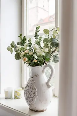 a white vase filled with flowers sitting on a window sill at Old Town Square Apartment in Prague