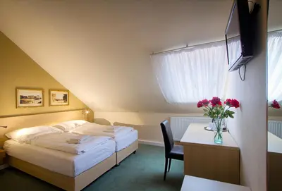 a hotel room with a bed and a table with flowers at Hotel Taurus in Prague