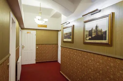 a hallway with a door and a picture on the wall at Hotel Taurus in Prague