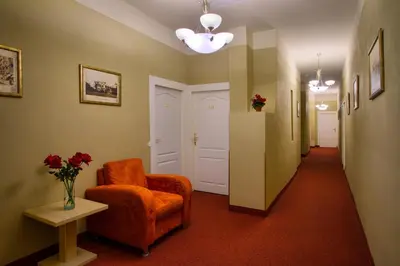 a hallway with a chair and a vase of flowers at Hotel Taurus in Prague