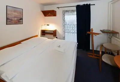a bedroom with a white bed with a cross on it at Hotel Wolf in Prague