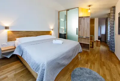 a bedroom with a large bed and a mirror at Hotel Wolf in Prague