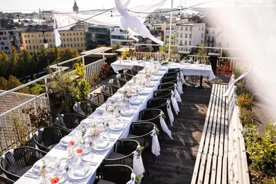 a long table with white tables and chairs on a balcony at Pytloun Boutique Hotel Prague in Prague