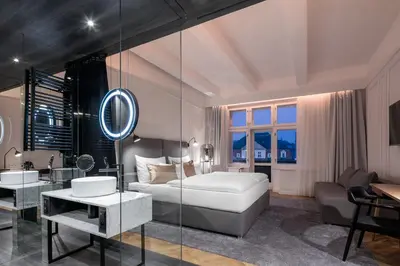 a bedroom with a tub and a bed and a sink at Pytloun Boutique Hotel Prague in Prague