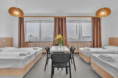 a room with two beds and a table with flowers at Abitohotel in Prague
