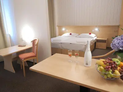 a hotel room with a bed and a table with wine glasses at Abitohotel in Prague
