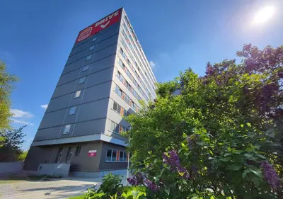 a tall building with a sign on the side of it at Abitohotel in Prague