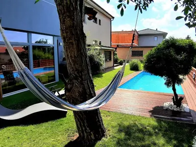 a hammock hanging from a tree next to a house at Holiday Home Řeporyje by Interhome in Prague
