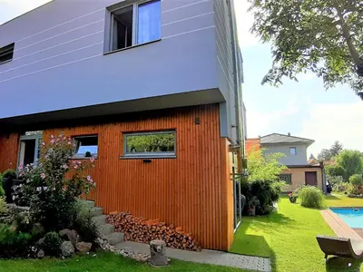 a house with an orange wall next to a yard at Holiday Home Řeporyje by Interhome in Prague