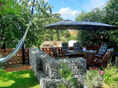 a table and chairs under an umbrella in a garden at Holiday Home Řeporyje by Interhome in Prague