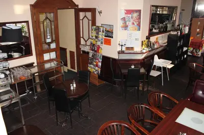 a restaurant with tables and chairs and a piano at Hotel Praha Club bed & breakfast in Prague