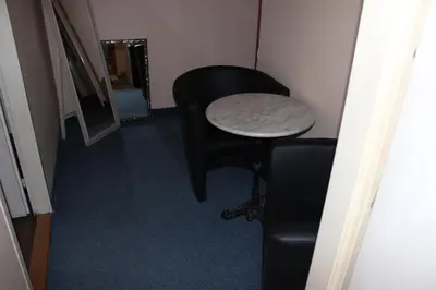 a room with a table and a black chair and a stool at Hotel Praha Club bed & breakfast in Prague