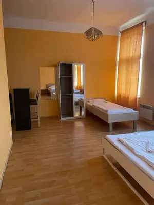 a large room with two beds and a mirror at Hotel Praha Club bed & breakfast in Prague