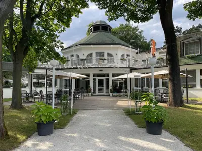 a large white house with tables and chairs at Hotel Ostrov in Nymburk