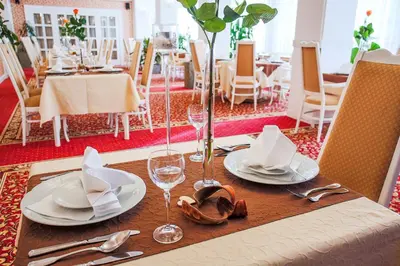 a table with plates and wine glasses on it at Hotel Ostrov in Nymburk