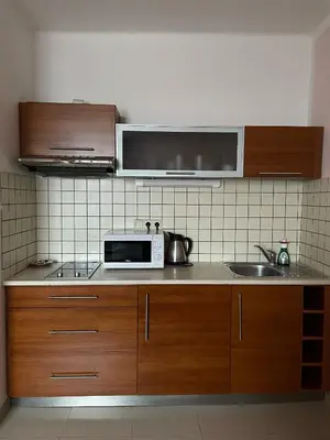 a kitchen with a microwave and a sink at Hotel Ostrov Garni in Sadská