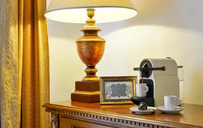 a lamp sitting on top of a table with a clock at Boutique Hotel Bijou de Prague in Prague