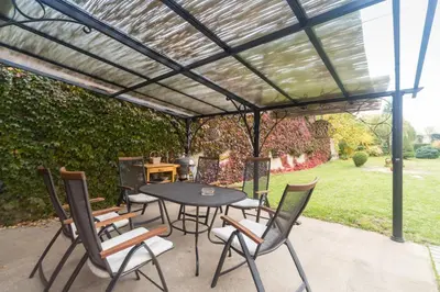 a pergola over a table and chairs on a patio at Budyně Apartment in Budyně nad Ohří