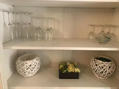 a shelf with glass vases and a box of flowers at Budyně Apartment in Budyně nad Ohří