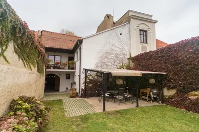 a house with a garden with a table and chairs at Budyně Apartment in Budyně nad Ohří
