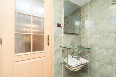 a bathroom with a sink and a mirror and a door at Budyně Apartment in Budyně nad Ohří