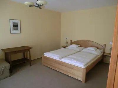 a bedroom with a wooden bed and a table at Pension Rondel in Poděbrady