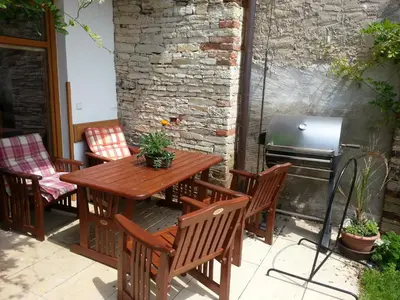a wooden table and chairs on a patio with a grill at Pension Rondel in Poděbrady