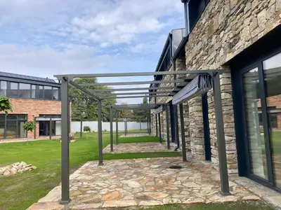 a stone building with a pergola outside of it at Palace Resort Jíloviště in Jíloviště