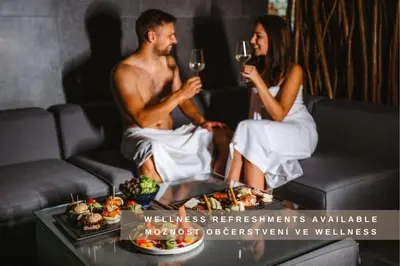 a man and a woman sitting on a bed at Hotel Frýdl in Prague