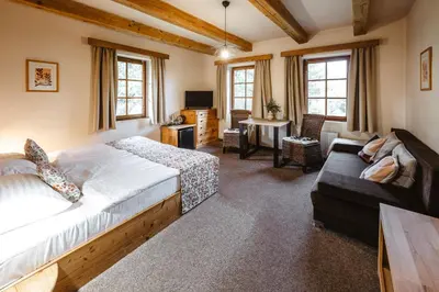a bedroom with a bed and a leather couch at Hotel Frýdl in Prague