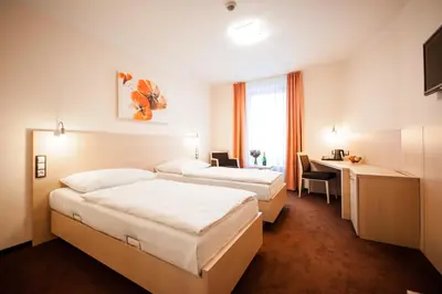 a hotel room with two beds and a desk at Hotel Pivovar in Prague