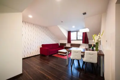 a living room with a red couch and a table at Hotel Pivovar in Prague