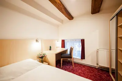 a hotel room with a desk and a bed at Hotel Pivovar in Prague
