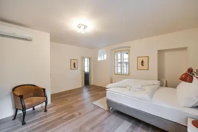 a bedroom with a bed and a chair in it at 18th CENTURY BAROQUE RESIDENCE in Prague