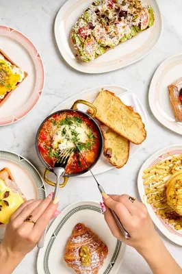 a table full of plates of food with people eating at W Prague in Prague