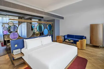 a bedroom with a large bed and a blue couch at W Prague in Prague